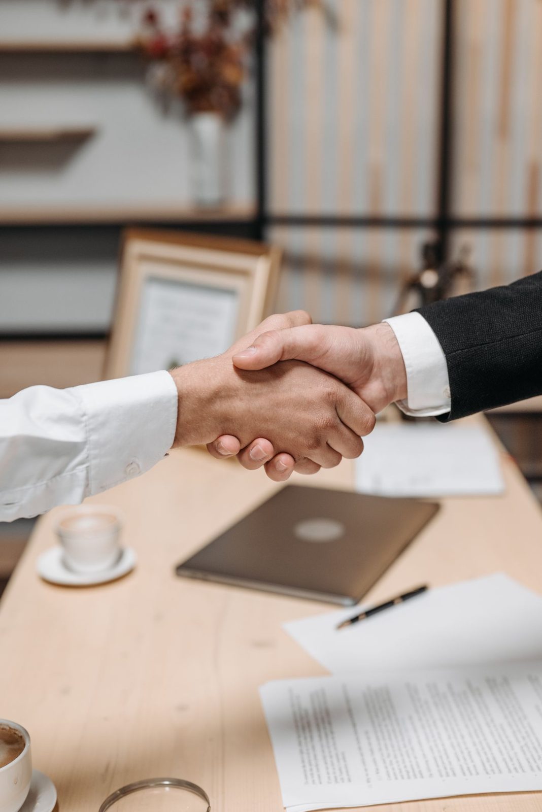 Aperto de mão sobre uma mesa de atendimento, simbolizando parceria
